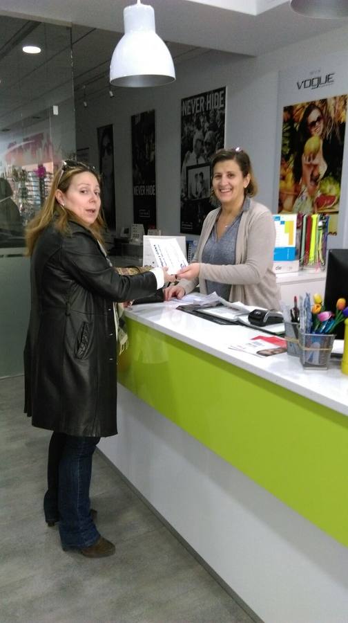 Centro Óptico Miajadas entregando una papeleta a una cliente