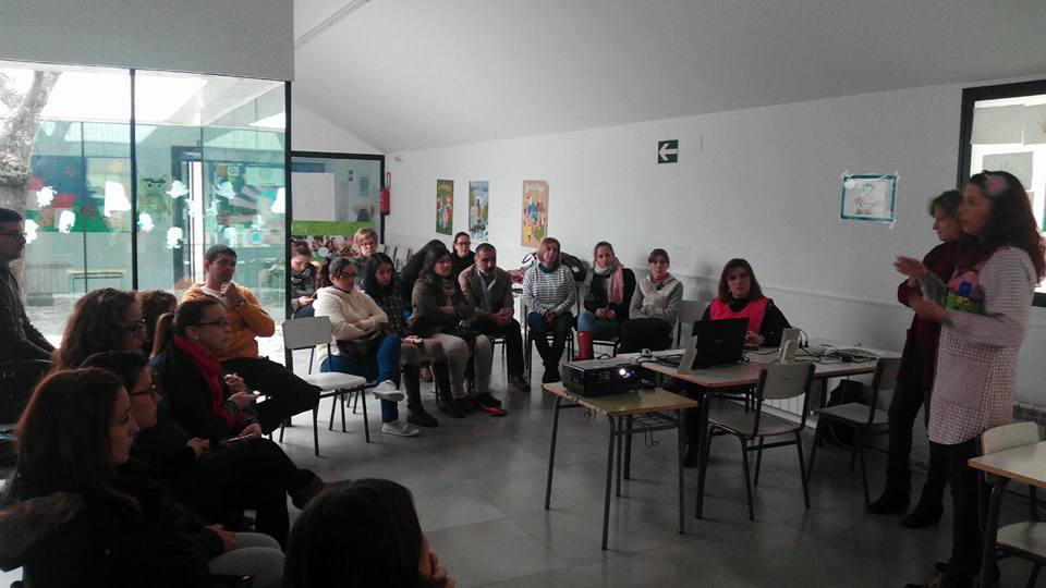 Padres y madres atendiendo a la explicación del proyecto del colegio. 