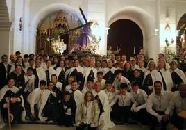 Foto de grupo de penitentes y costaleros de la Hermandad de Nuestro Padre Jesús Nazareno de Monesterio junto al paso