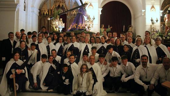 Foto de grupo de penitentes y costaleros de la Hermandad de Nuestro Padre Jesús Nazareno de Monesterio junto al paso