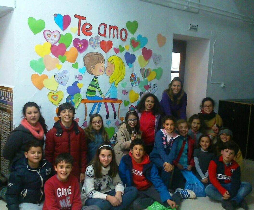 Profesora y alumnos posando frente al mural confeccionado por ellos mismos 