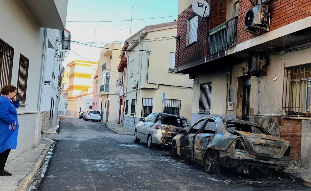 Una vecina observa el estado de los turismos afectados 