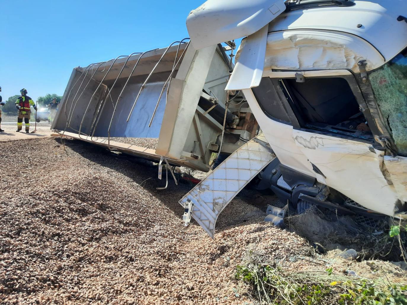 La carga de grava que transportaba quedó esparcida por la cuneta