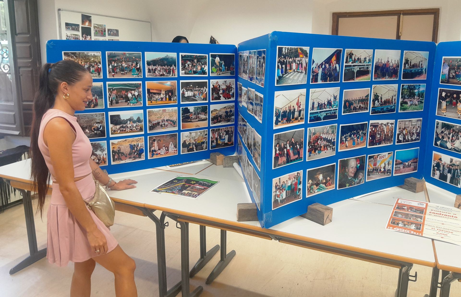 Joven integrante de la formación ante las fotografías expuestas