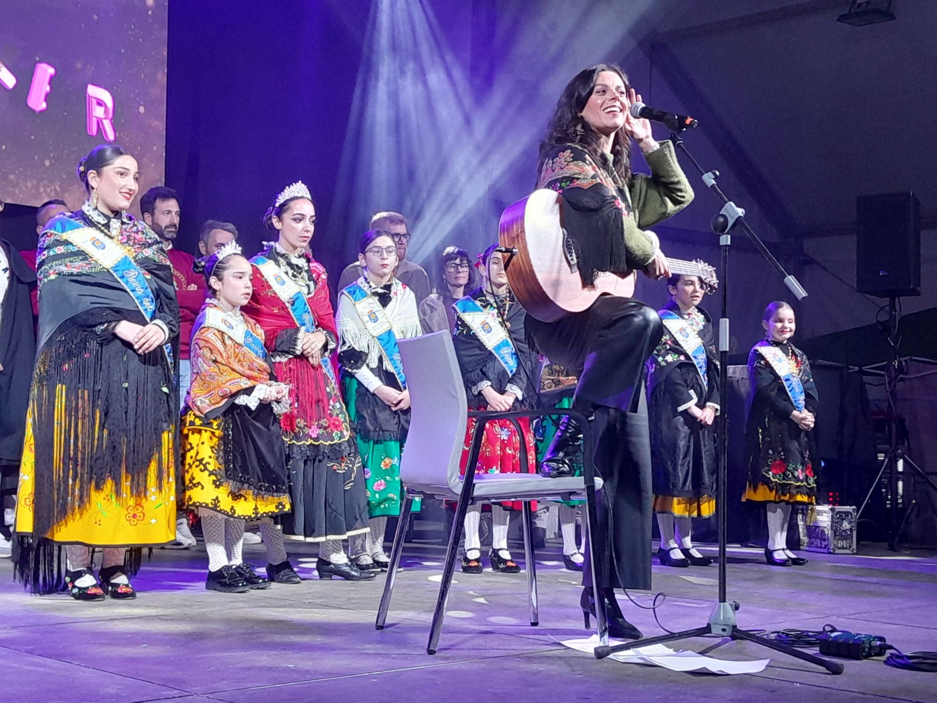 La pregonera escucha cantar al público que llenaba la caseta municipal