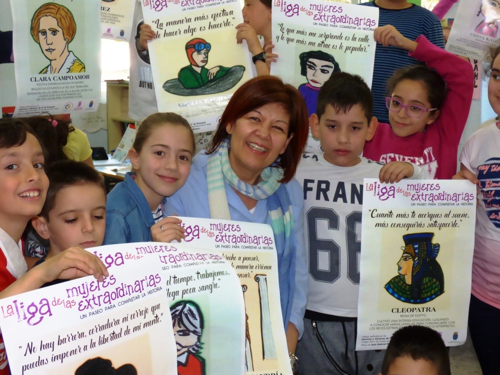 La profesora con sus alumnos y detalle de uno de los carteles elaborados 