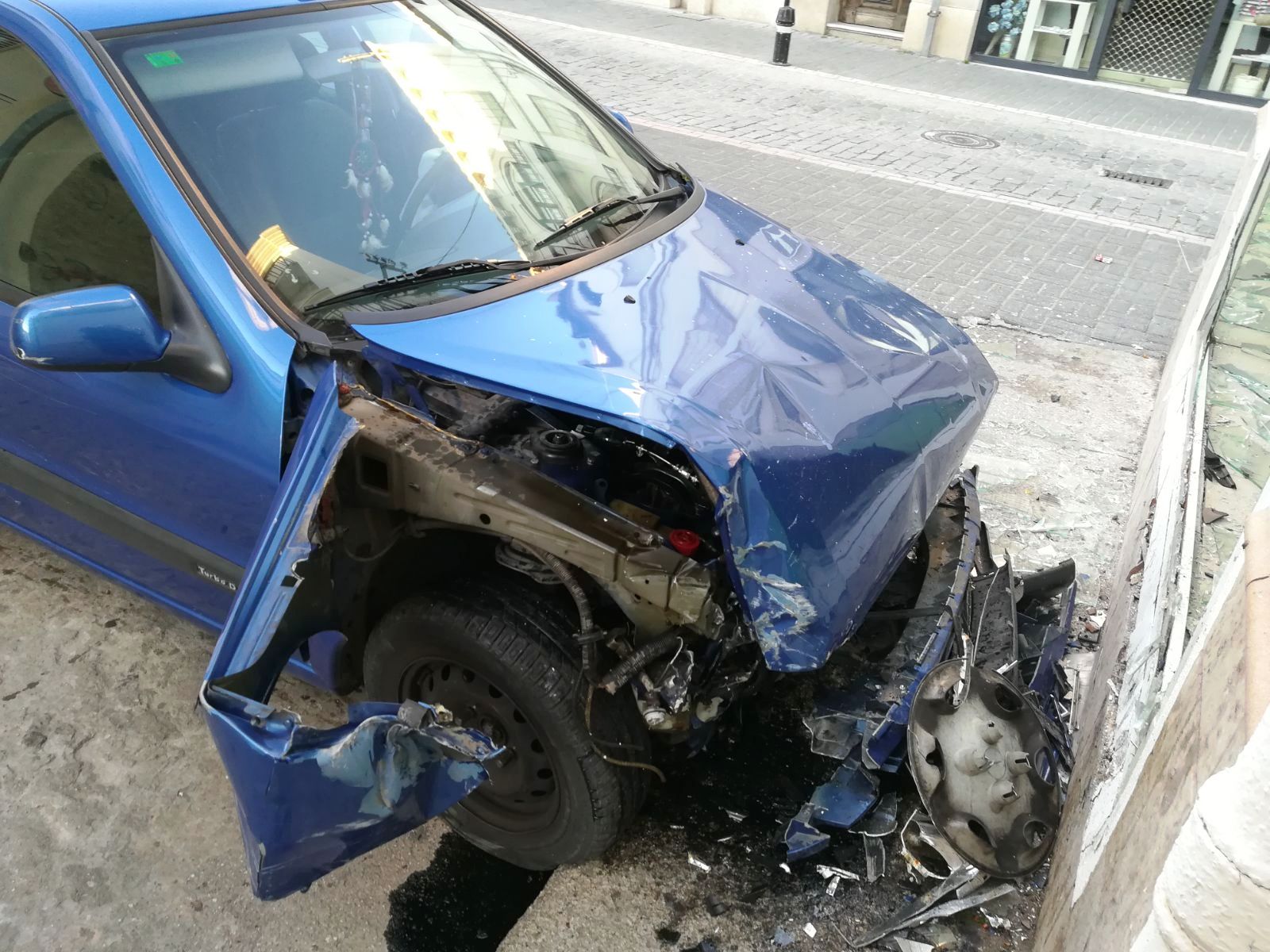 Una conductora, imputada por delito contra la seguridad vial tras golpear a varios vehículos y  señales y chocar con la cristalera de una tienda