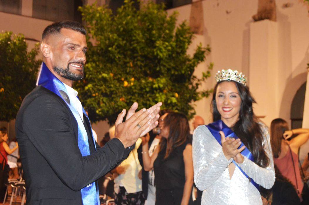 Imagen principal - Arriba, Bartolomé Carreira y Cristina González, ganadores del certamen de belleza; abajo, a la izquierda, la Miss y el Mister, acompañados por los componentes del jurado; a la derecha, el organizador del certamen, Rubén Margallo, flanqueado por González y Carreira. 