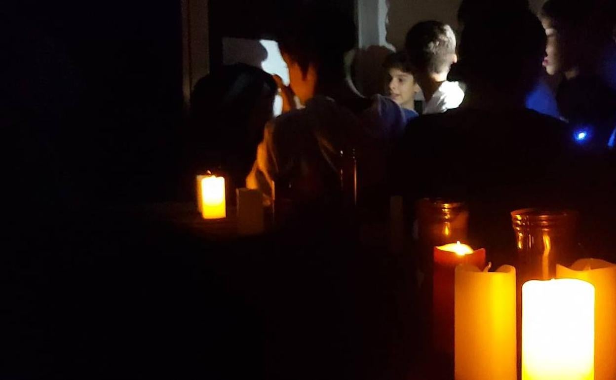 Los participantes se movieron en la penumbra de la luz de las velas