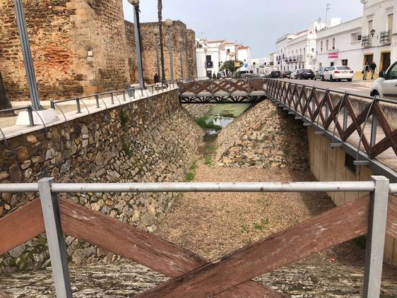 Los operarios municipales retiran basura del foso del castillo tras su limpieza rutinaria