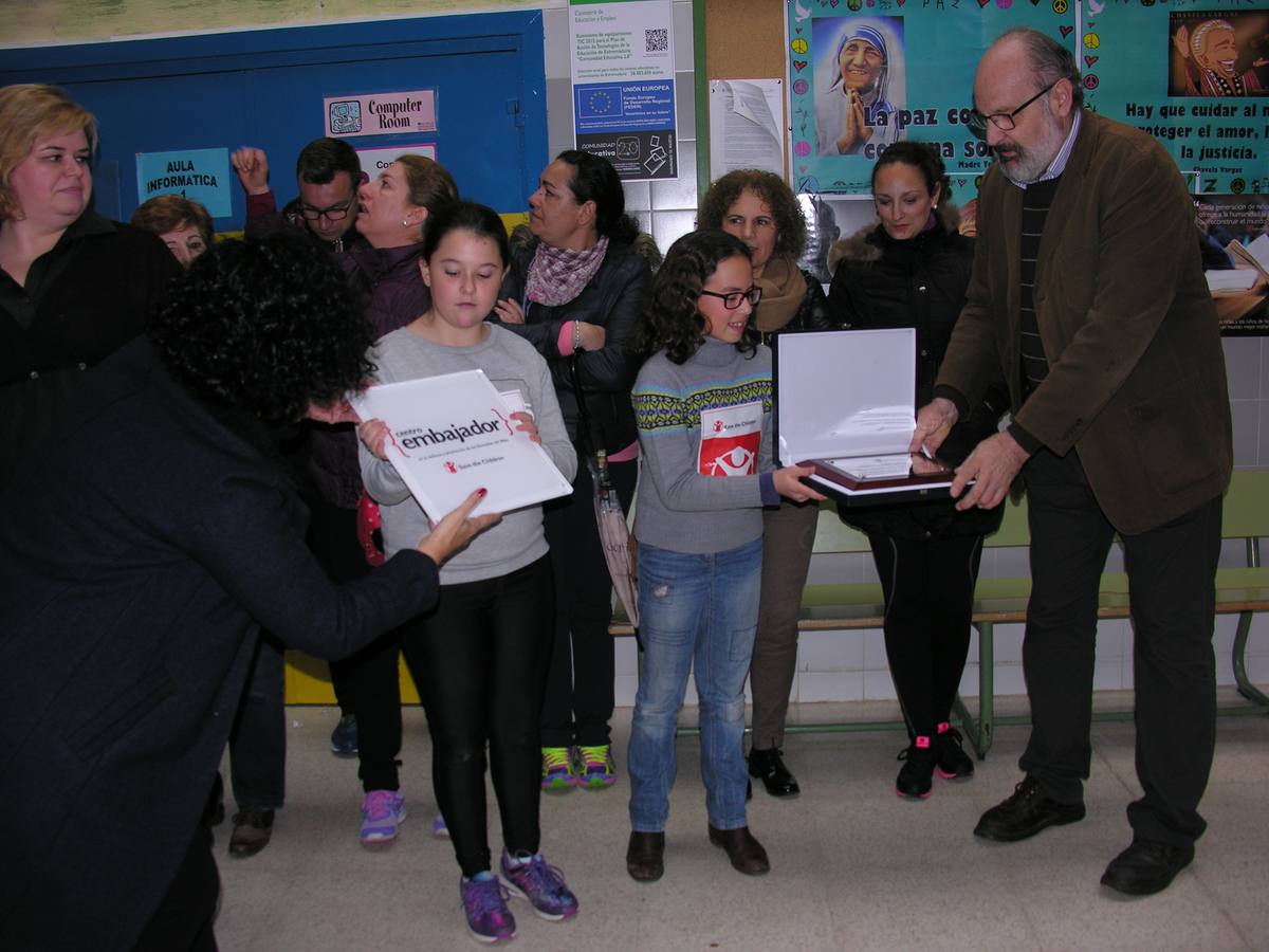 Dos alumnas recogen las placas de manos de Juan Guilló y Marisol Paniagua, representantes de Save the Children. 
