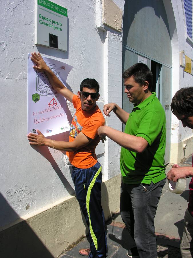 Dos usuarios de Aprosuba-14 colocan un cartel en el Espacio de Creación Joven. 