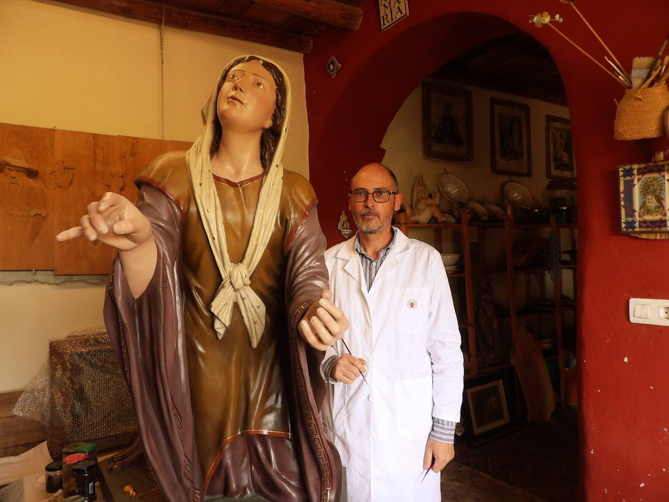 Juan José MInaya con la imagen en su taller durante la restauración 