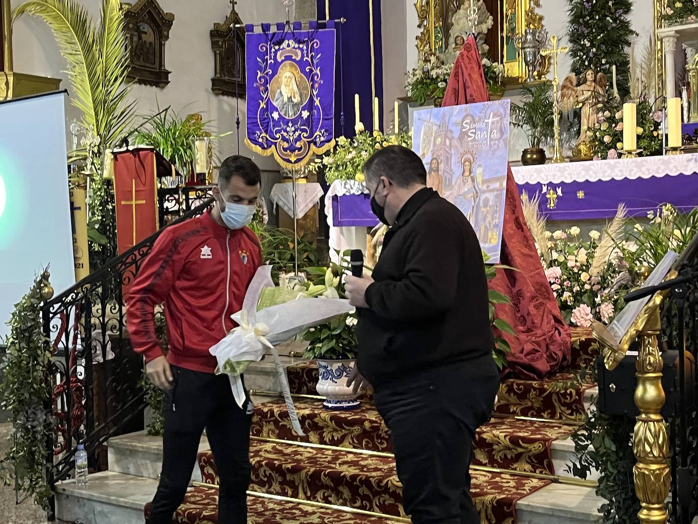 Lolo muestra el ramo al párroco, Antonio Nogales antes de subirlo a la imagen 
