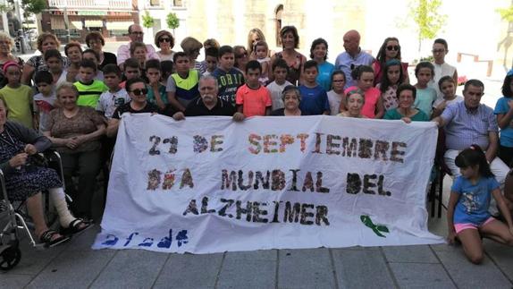 NIños y mayores sujetan la pancarta del centro terapeútico 