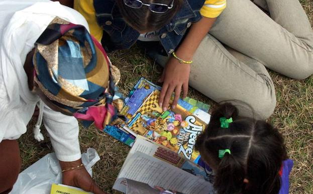 Niños ojeando revistas en Cuba.