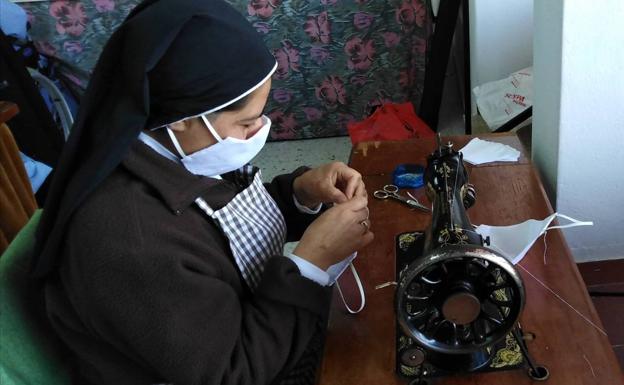 Una de las hermanas de Santa Ana cosiendo a máquina las piezas de tela para hacer mascarillas..