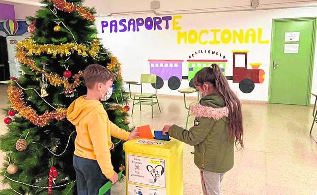 Dos alumnos del Santa Engracia introducen sus cartas en el buzón.