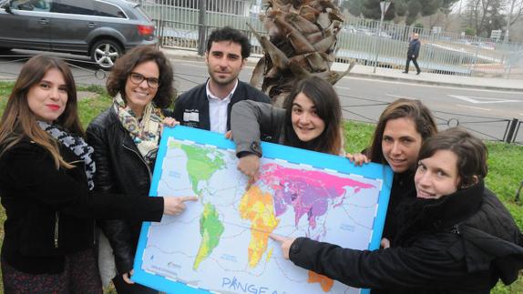 Sara Peligros, Sandra Muñoz, Moisés Sánchez, Laura Sánchez, Elvira Cano y Begoña Lozano señalan sobre un mapa los países en los que trabajarán como cooperantes.