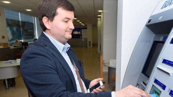 Un cliente con discapacidad visual haciendo una retirada de efectivo con la ‘app’ BBVA para todos.