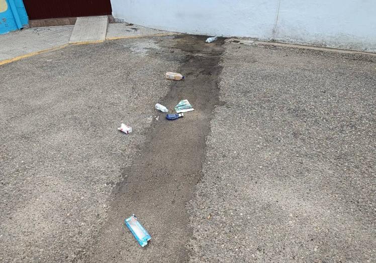 Imagen principal - Basura y botellas rotas en el suelo.