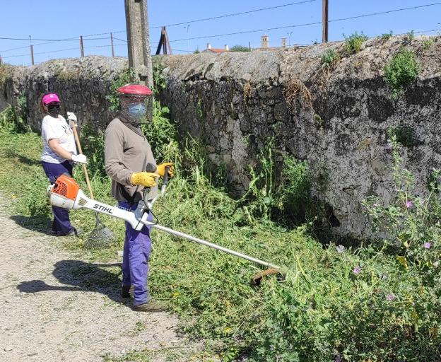 Personal municipal en la limpieza de malas hierbas 