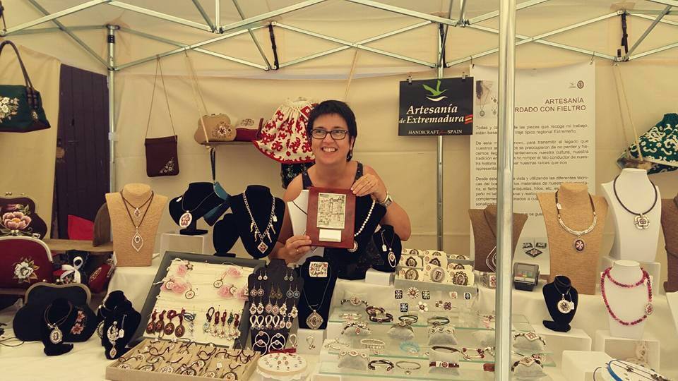 Chari Bravo, en el stand en Plasencia, con el galardón