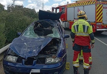 El helicóptero llega al lugar del accicente. En primer plano, un ombero junto al vehículo siniestrado