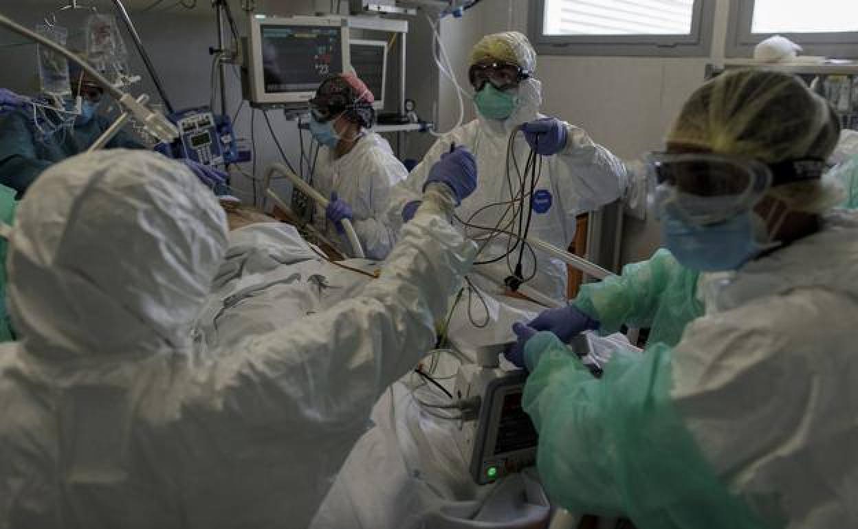 Sanitarios atendiendo a un paciente en una UCI de covid. / 