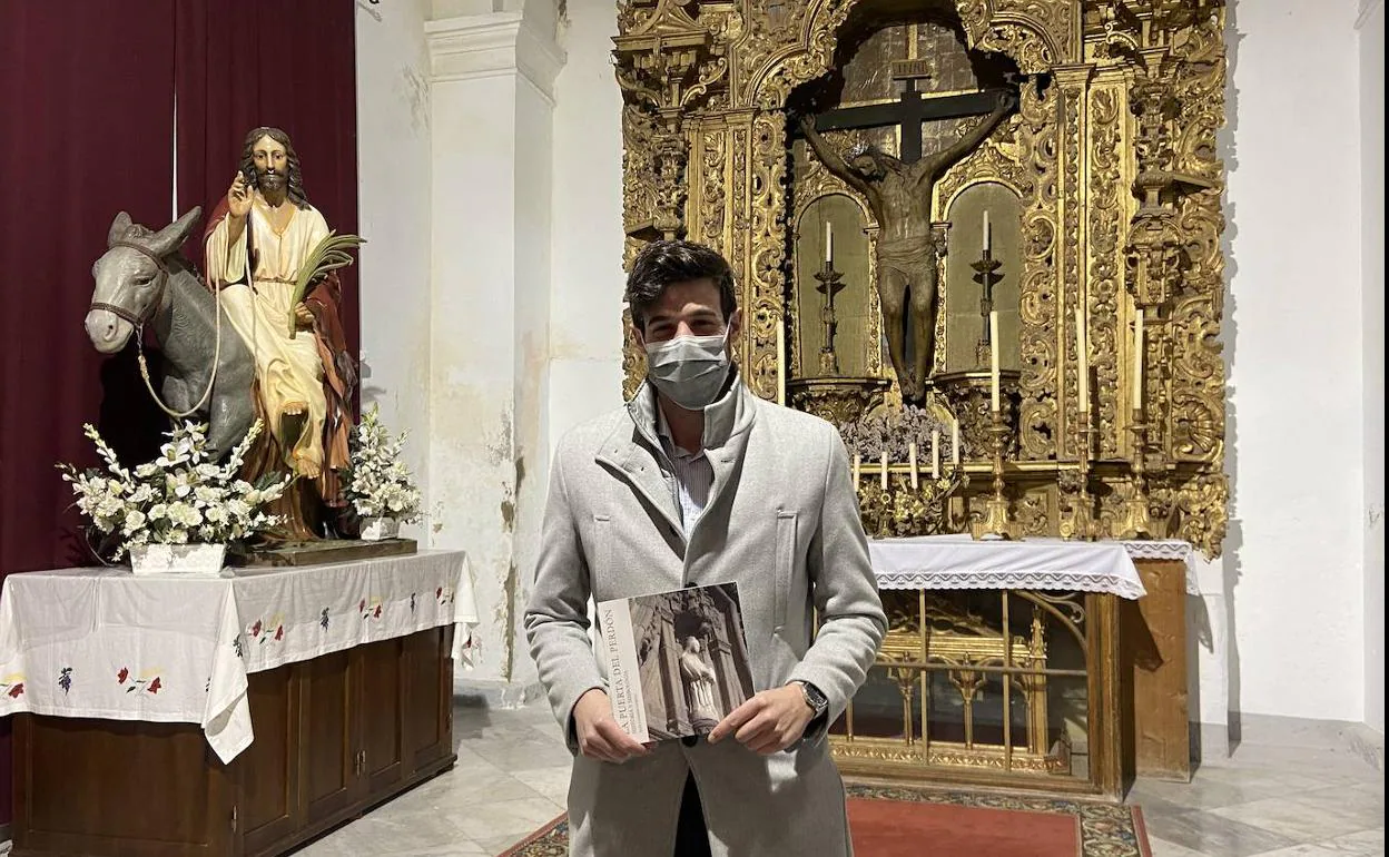 Juan Garrido portando su libro delante del Santo Cristo de la Misericordia 
