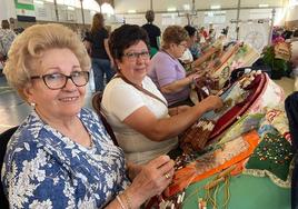 Dos encajeras de bolillos realizan sus labores en la feria de Villafranca.