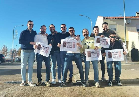Los nueve agraciados posan con el número premiado.