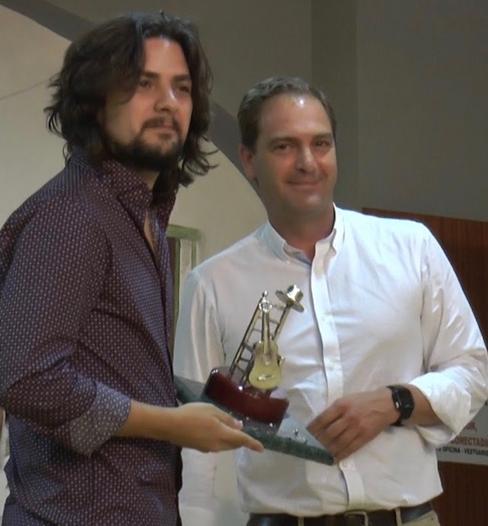 Edu Hidalgo recoge el premio de manos del concejal de Cultura, Lorenzo García Ramos. 