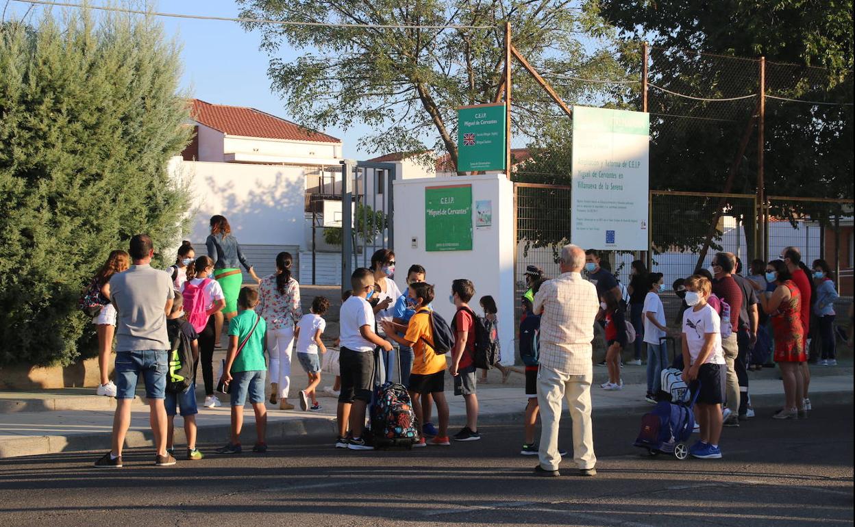 Grupo de niños y padres a la entrada del colegio. 