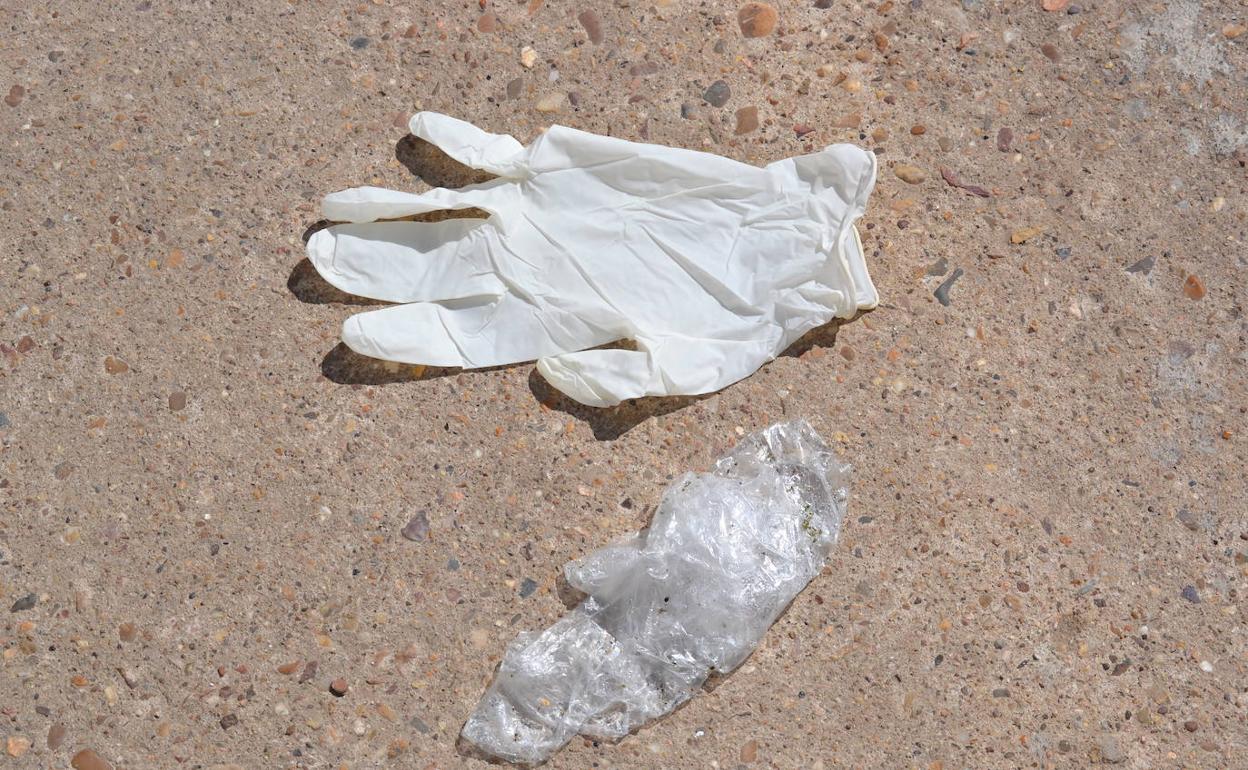 Guantes desechables en el suelo de la calle.