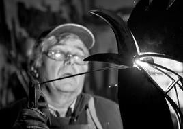 El artista Antonio Viera soldando en su taller.
