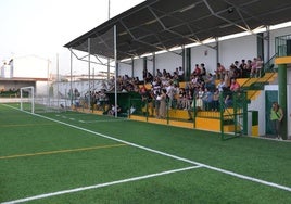 Gradas del campo de fñutbol municipal en el trasncurso de un partido.