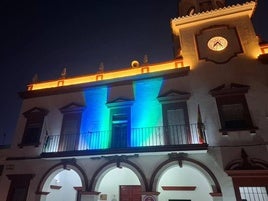 Fachada del Ayuntamiento iluminada en verde y azul.