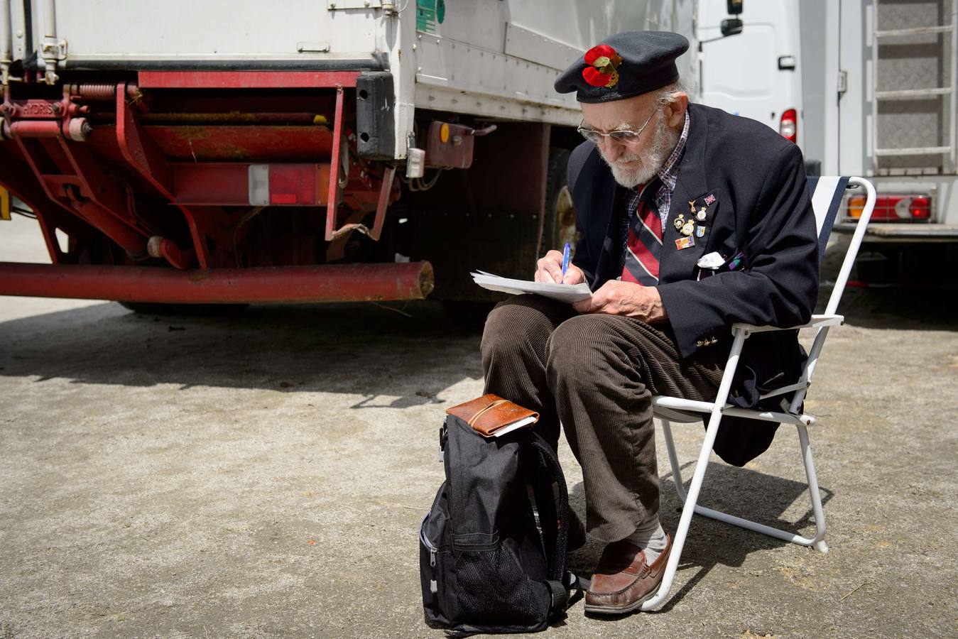 Un veterano escribe una postal después del evento de conmemoración del Día D en el puente Pegasus en Benouville, el norte de Francia. AFP PHOTO / LEON NEAL