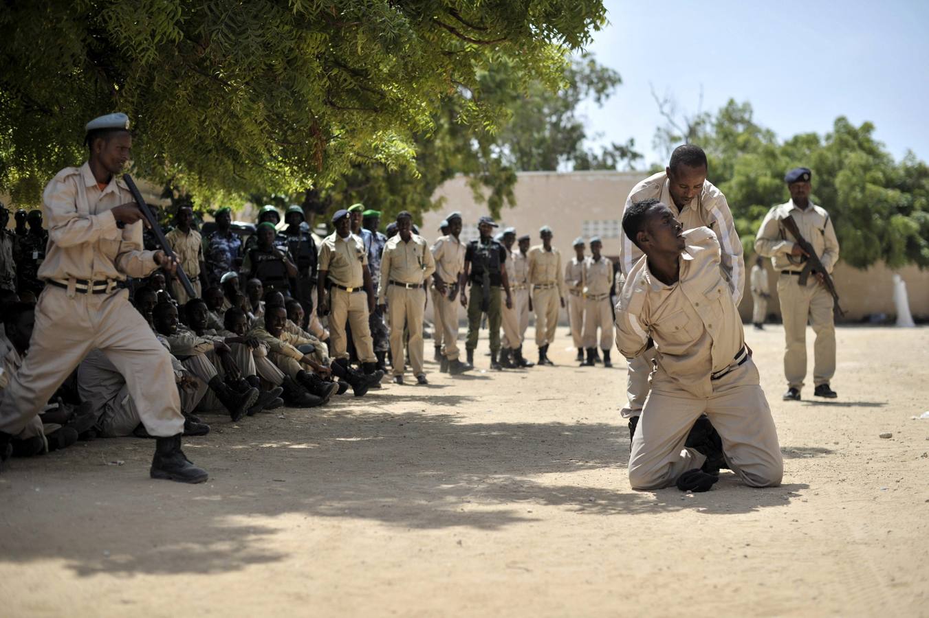 Fotografía que muestra a varios oficiales de policía de la Unión Africana durante un ejercicio de entrenamiento sobre los métodos adecuados para esposar y arrestar a una persona en la academia de policía General Kahiye, en Mogadiscio, Somalia.