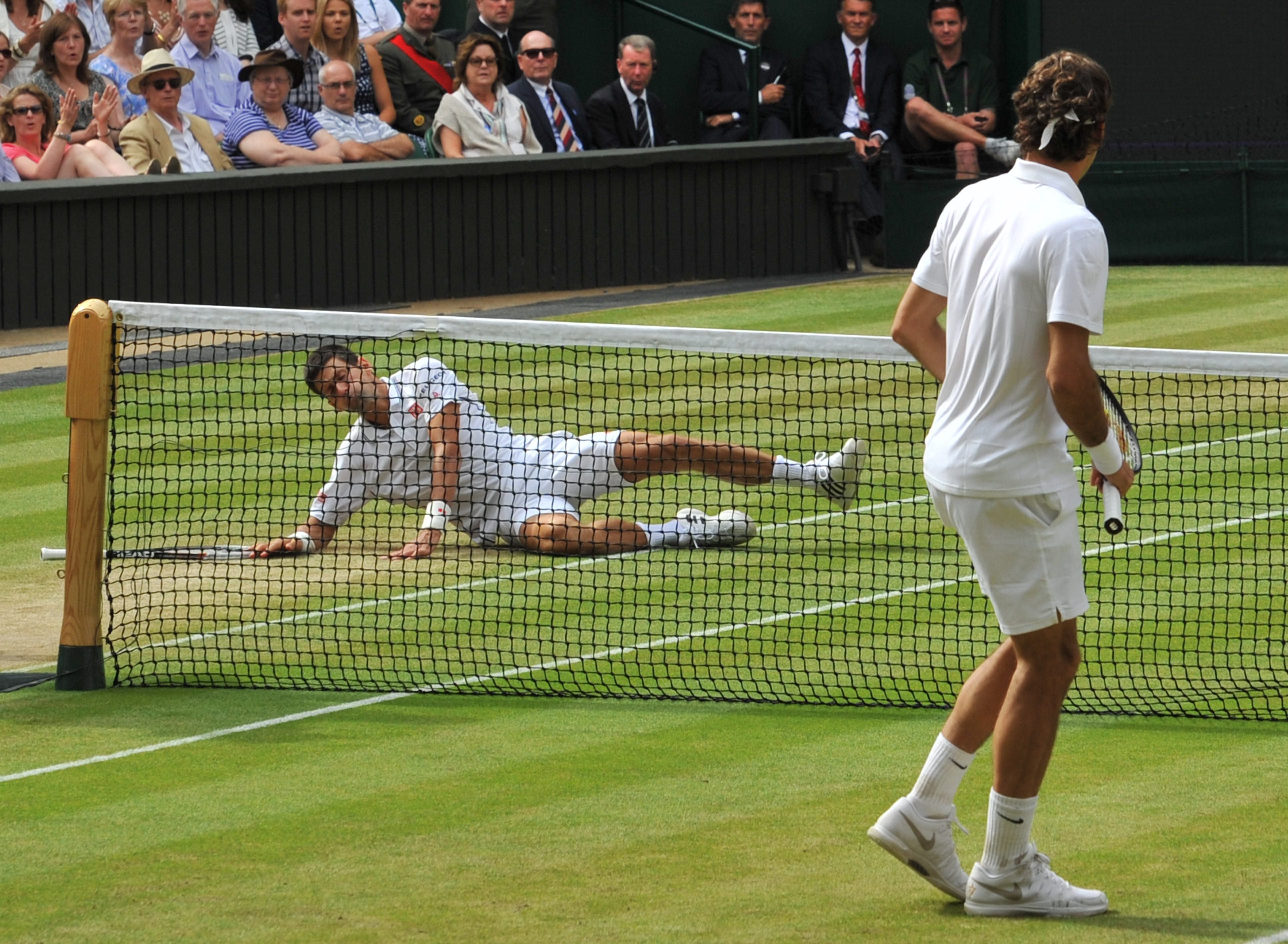 Djokovic (i), en el suelo, tras un punto ganado por Federer (d).