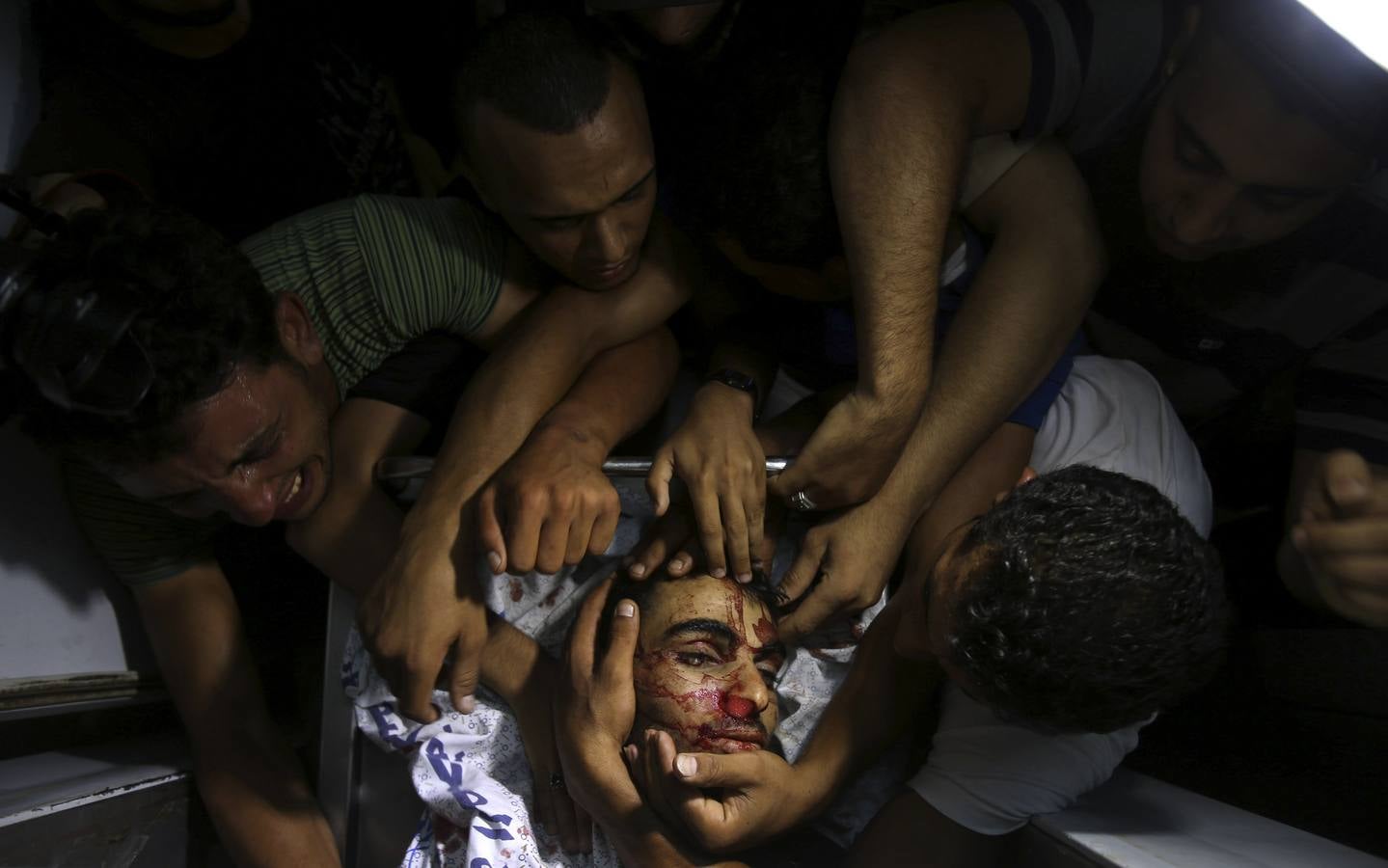 Lunes, 7 de julio. Momento deduelo por un militante palestino en la morgue de un hospital en el centro de la Franja de Gaza después del bombardeo israelí. REUTERS / Ibraheem Abu Mustafa