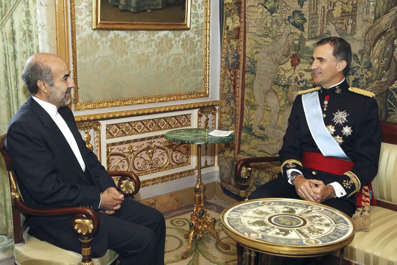 El Rey Felipe VI conversa con el embajador de Irán, Mohammad Hassan Fadaifard (i)