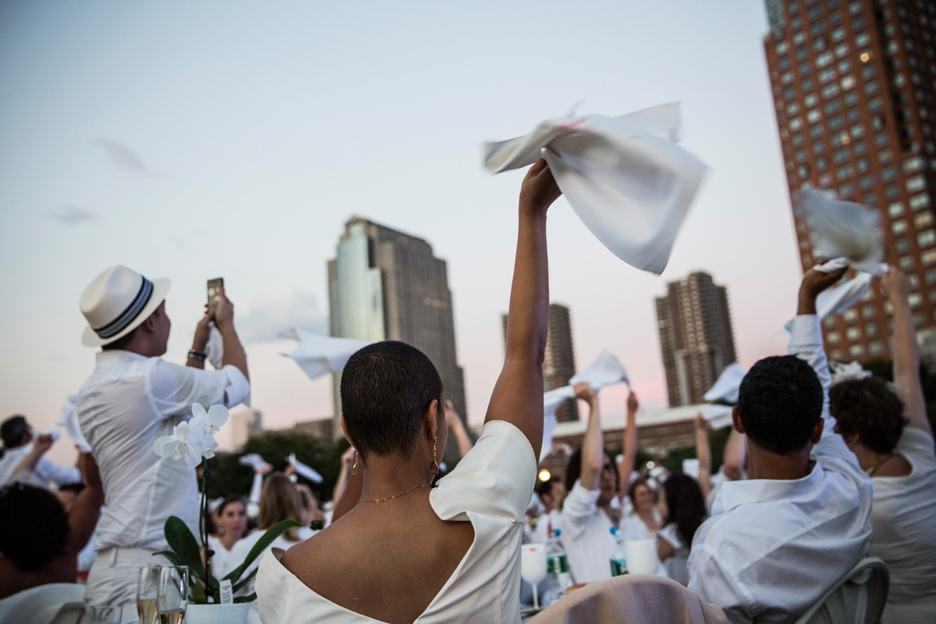Lunes, 25 de agosto.  'The Diner en Blanc' es el único evento culinario viral del mundo. Celebra su 25 aniversario al aire libre y siempre en un lugar histórico. Los invitados deben vestir de un elegante color blanco, llevar una cesta de picnic con comida, vajilla de porcelana y cubiertos, manteles blancos, mesas y sillas. En esta ocasión 'Battery Park City' ha acogido a unas 5.000 personas. Fotos: Getty Images/AFP