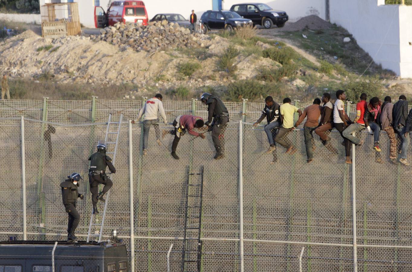 Decenas de inmigrantes encaramados en la valla fronteriza de Melilla