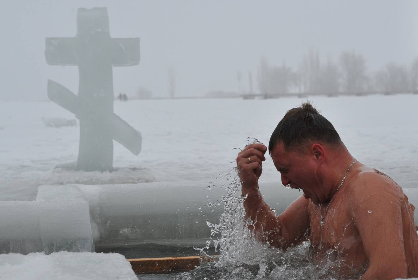 Fieles ortodoxos se sumergen en las aguas heladas de un lago, durante la celebración de la festividad de la Epifanía cerca del pueblo de Sretinka, a unos 40 kms de Bishkek. Entre los cristianos ortodoxos, la fiesta de la Epifanía celebra el día que el Espíritu de Dios descendió sobre los creyentes en forma de paloma durante el bautismo de Jesucristo en el río Jordán. Fotografía: AFP-Vyacheslav Oseledko