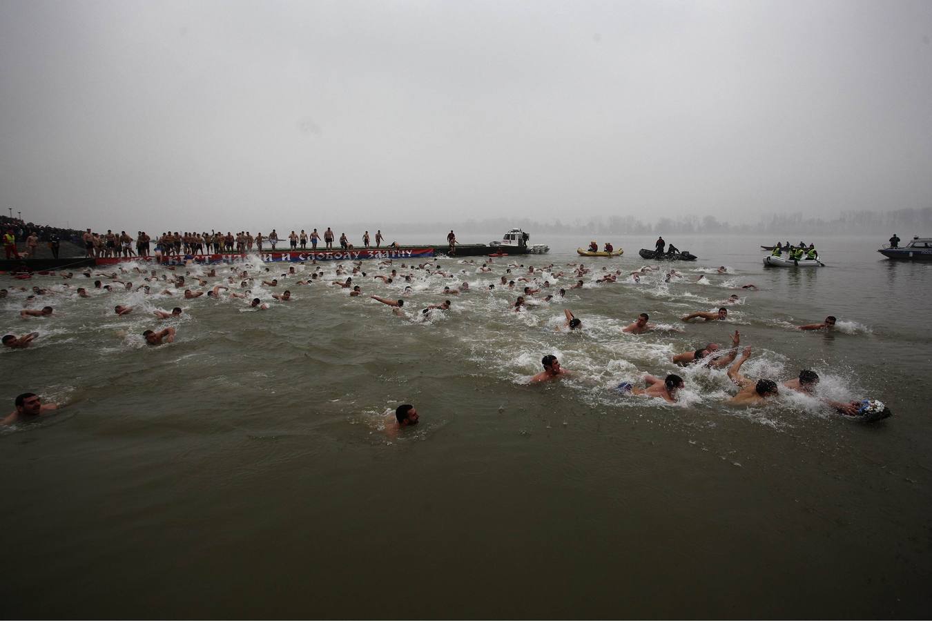 Algunos hombres nadan en el río Danubio, en un intento de apoderarse de una cruz de madera en el Día de la Epifanía, en Belgrado, Serbia. Fotografía: REUTERS-Djordje Kojadinovic.