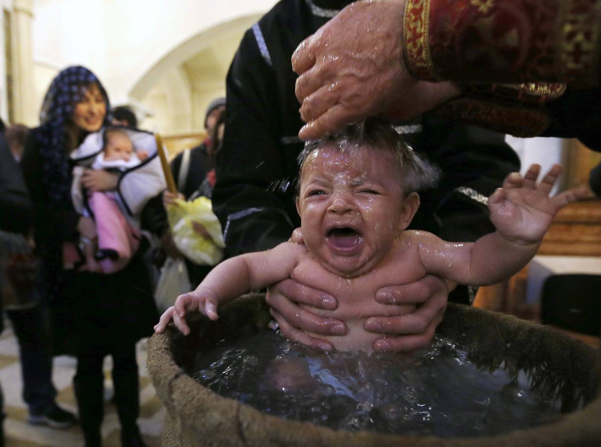 Bebés bautizados durante una ceremonia de bautismo en masa en el día de la Epifanía en Tbilisi. Alrededor de 1.000 niños fueron bautizados por la Iglesia Ortodoxa de Georgia durante la 38ª ceremonia de bautismo en masa en la catedral principal del país. REUTERS / David Mdzinarishvili