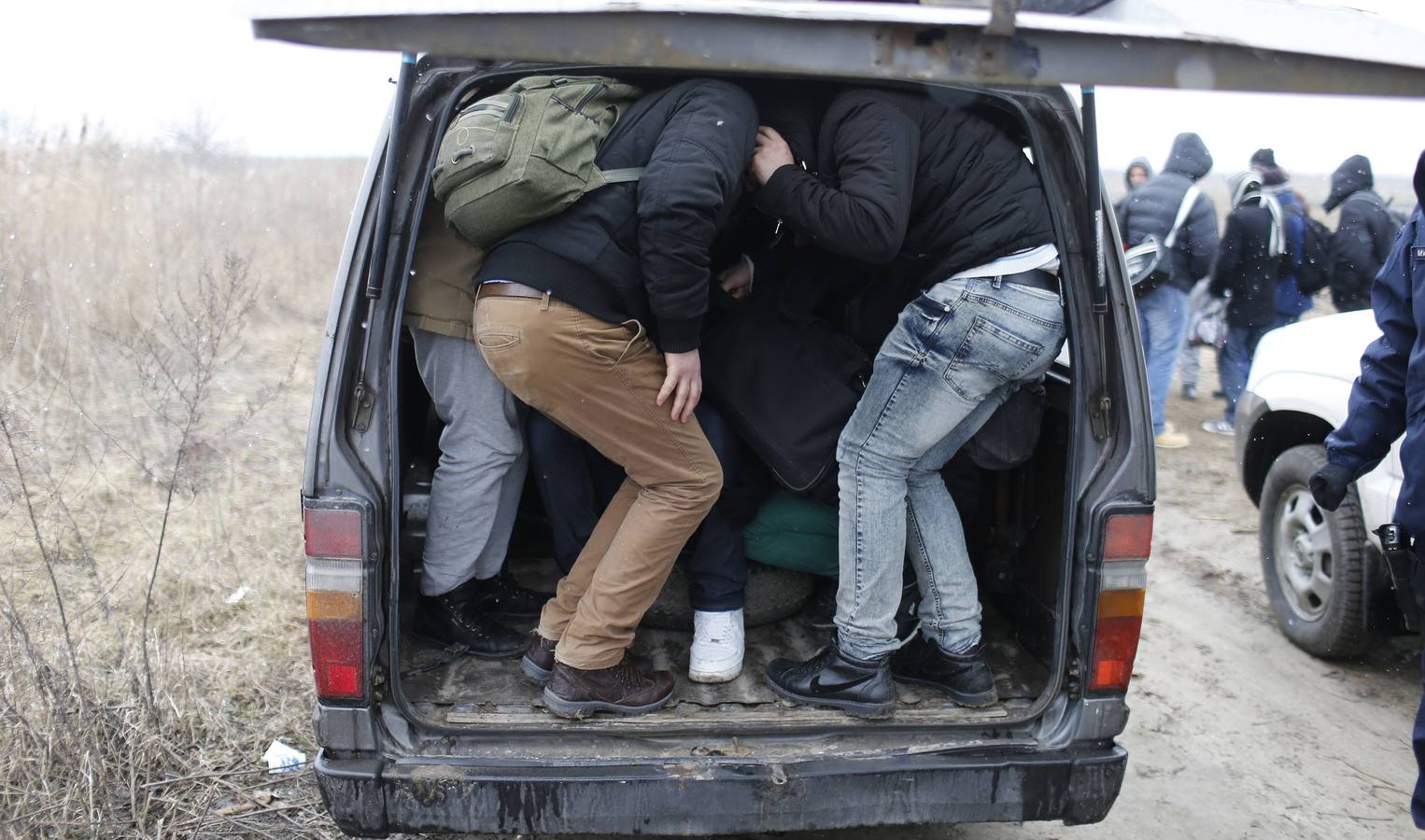 Un policía serbio recoge la documentación de un grupo de habitantes de Kosovo, después de que fueran detenidos cuando trataban de cruzar la frontera hacia Hungría, cerca de la ciudad de Subotica. Fotografía: REUTERS / Marko Djurica