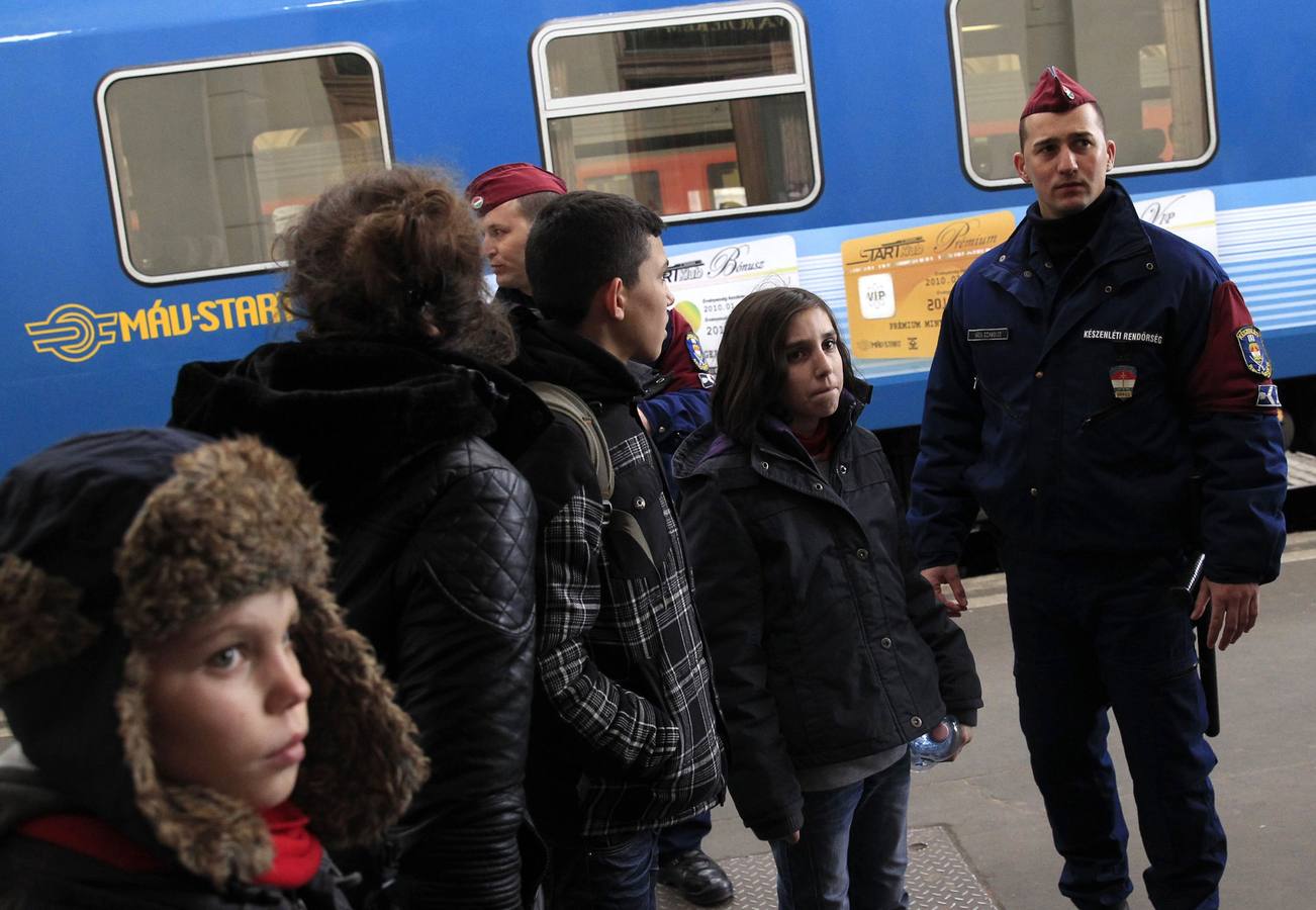 Polícias de Hungría comprueban los documentos de una familia de Kósovo en la estación de tren de Budapest. Fotografía: REUTERS / Bernadett Szabo